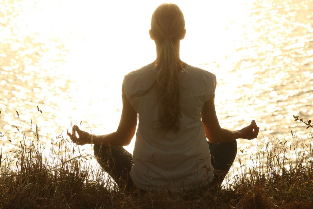 viaggi meditazione ridurre stress e ansia donna medita lago natura